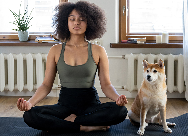 Woman and dog meditating at home with help from patented consumer products